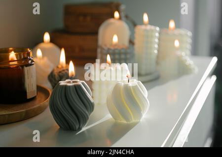 Cera naturale fatta a mano e candele di soia che bruciano. Concetto di salute mentale, cura di sé, stile di vita mentale Foto Stock