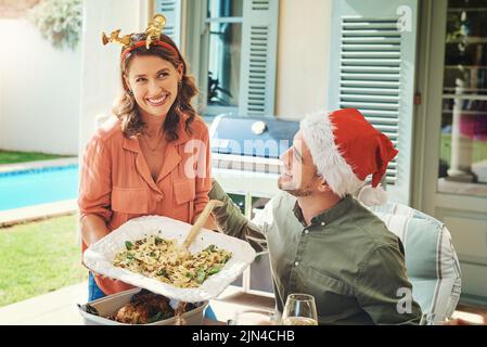 Tutto quello che desideravo per questo Natale: Una bella giovane coppia che mangiava insieme a un pranzo di Natale. Foto Stock