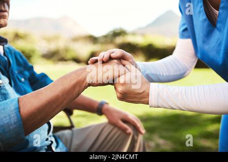 Spero che sappiate quanto mi interessa, una donna irriconoscibile che tiene le mani di un uomo anziano. Foto Stock
