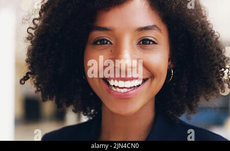 Il mio sorriso è una curva che pone tutto dritto. Ritratto corto di una giovane donna d'affari attraente sorridente e in piedi in ufficio durante il Foto Stock