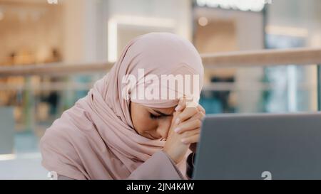 Giovane arrabbiato arabo donna che riceve e-mail legge cattive notizie su laptop lettera con rifiuto problemi di salute Avviso bancario per il prestito rifiuto licenziamento dal lavoro Foto Stock