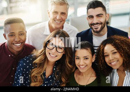 Un gruppo diversificato di designer creativi sorridenti che si sentono sicuri, felici e allegri dopo un incontro di successo in ufficio. Ritratto di squadra ambiziosa di Foto Stock