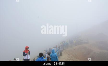 YANBIAN, CINA - 7 AGOSTO 2022 - i turisti visualizzano il Lago Tianchi alla vetta protetta dalla nebbia sulla pendenza settentrionale del monte Changbai nel nord-est della Cina Foto Stock