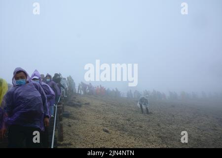 YANBIAN, CINA - 7 AGOSTO 2022 - i turisti visualizzano il Lago Tianchi alla vetta protetta dalla nebbia sulla pendenza settentrionale del monte Changbai nel nord-est della Cina Foto Stock