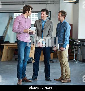 Colleghi di sesso maschile in piedi insieme e parlare mentre si prende una pausa dal lavoro. Moderno architetto team di uomini che progettano una collaborazione di squadra Foto Stock