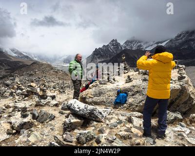 Gli escursionisti si posano sul morano sopra il Ghiacciaio di Khumbu vicino a Lobuche sull'Everest base Camp Trek, Nepal. Foto Stock