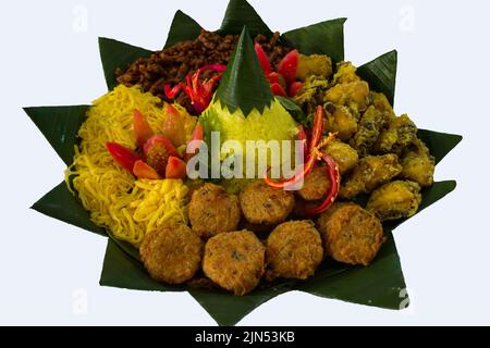 'il kuning di nasi o riso giallo è cibo tradizionale giavanese, indonesia servito con pollo fritto, gnocchi di perkedel o patate, involtini di uova e orchi Foto Stock