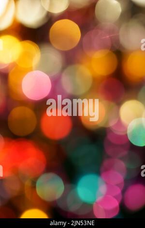 Primo piano delle luci della città di notte sullo sfondo con luci al neon colorate, fuoco sfocato Foto Stock