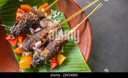 il bontel di sate o il bontel di satay è fatto di montone tritato avvolto in grasso di montone e poi cotto alla griglia. condimento con pomodori, scalogni, pepe, cavbag Foto Stock