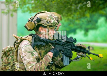 27 luglio 2022 - Camp James A. Garfield Joint MIL, Ohio, USA - Tech. SGT. Britney Simpson, uno studente del corso di leadership sulla difesa integrato assegnato allo Squadrone delle forze di sicurezza 927th, la base dell'aeronautica di MacDill, Florida, guida la sua squadra in un assalto a una posizione di forza opposta durante un esercizio di operazioni di sicurezza dell'area al Camp James A. Garfield Joint Military Training Center, Ohio, 27 luglio 2022. L'esercizio è stato parte della IDLC di due settimane con sede alla stazione aerea di Youngstown, Ohio, e utilizzando i campi di addestramento alla CJAG. IDLC è stato progettato per fornire ai difensori di riserva un ha intensamente focalizzato Foto Stock