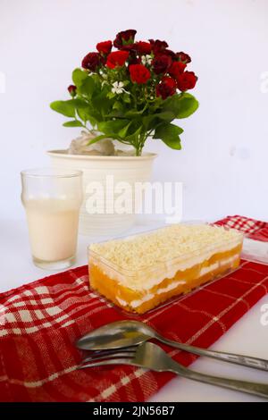 Tres Leches Cake o bagno al latte servito con cucchiaio e forchetta, isolato su fondo bianco Foto Stock