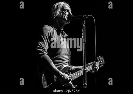 Un'immagine monocromatica di Paul Weller che canta e suona la chitarra su sfondo nero durante il concerto della Venue Cymru Arena a Llandudno. Foto Stock