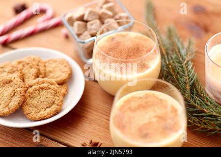 bicchieri di eggnog, biscotti di farina d'avena e ramo di abete Foto Stock