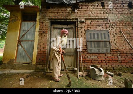 Powt, India. 05th ago 2022. Pritam Khan di fronte alla sua casa nel villaggio di Powt nello stato indiano di Punjab. Pritam aveva circa nove anni quando gli inglesi annunciarono la divisione del loro ex impero coloniale India britannica in India e Pakistan nel 1947. Nelle rivolte settarie che seguirono la divisione, Pritam perse la sua famiglia, che fuggì in Pakistan. Oggi è tornato in contatto con il nipote Shahbaz. Credit: Himanshu Mahajan/dpa/Alamy Live News Foto Stock