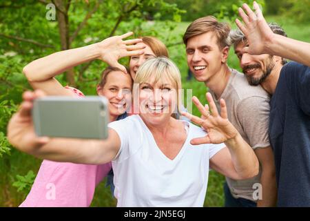 Gruppo di amici o famiglia si divertono a prendere selfie con smartphone in vacanza Foto Stock