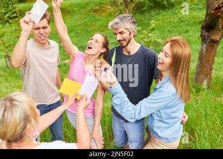 Gruppo di persone che si divertono nel gioco introduttivo creativo in team building workshop Foto Stock
