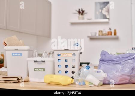 Immagine orizzontale di rifiuti separati in diversi contenitori in piedi sul tavolo in cucina Foto Stock