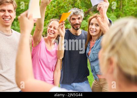 Gruppo di giovani in team building workshop creativo utilizzando carte colorate per conoscere Foto Stock