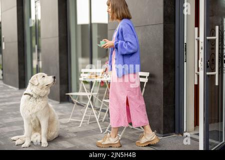 Donna con cane al bar all'aperto Foto Stock