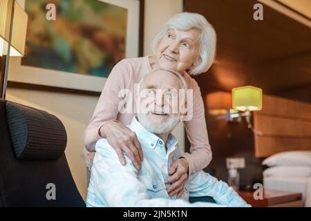Coppia anziana in una bella camera che ha un aspetto felice e tranquillo Foto Stock