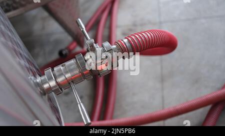 Attrezzatura industriale per tubi in acciaio inox con rubinetto e tubo per la produzione di vino o chimica farmaceutica Foto Stock