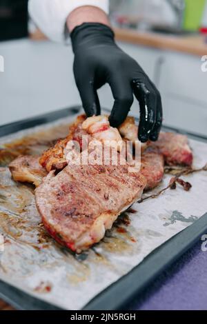 Bistecca di manzo con verdure su un piatto nero. Bistecca con basilico cucinata nella lezione di cucina Foto Stock