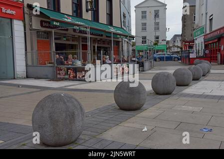 La gente si sedette ai tavoli al di fuori dei tradizionali pub irlandesi nella piazza di Dominick Street, Tralee, County Kerry, Irlanda, 2022 luglio Foto Stock