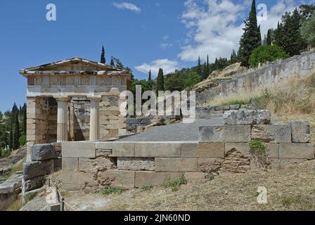 Vista del Tesoro ateniese; la Stoa degli ateniesi sulla destra a Delfi, Grecia Foto Stock