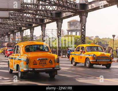 Vecchi taxi Hindustan Ambassador che attraversano il primo ponte di Hooghly, a Calcutta / Kolkata, noto anche come il Rabindra Setu. Foto Stock