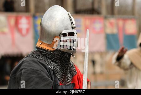 Uomo del Reenattore vestito in armatura di un vecchio Rus footman ricostruire la lotta di spada, fortezza di legno su uno sfondo. Kiev, Ucraina Foto Stock