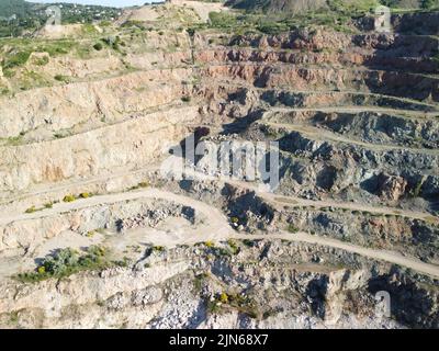 Vista aerea dall'alto sulla cava di opencast con fondo allagato, superficie turchese del lago. Laghetto di cava cresciuto con piante verdi e limpide Foto Stock