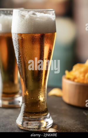 Bicchieri pieni di birra leggera con gocce sul lato in primo piano bar. Alcol, intrattenimento, bevande tradizionali, concetto di atmosfera Oktoberfest. Vertica Foto Stock