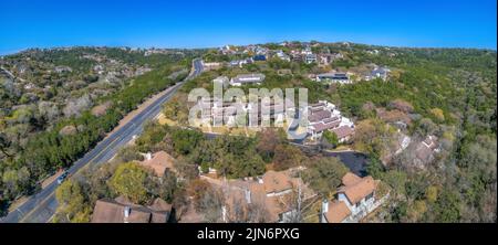 Vista aerea di un'area residenziale e strada autostradale di Austin, Texas. Ci sono grandi case con alberi all'esterno e una vista di una strada dritta sul Foto Stock