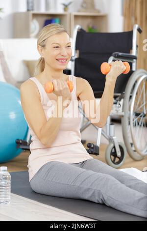 donna anziana determinata che fa le esercitazioni nel paese con i dumbbells Foto Stock