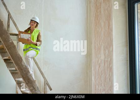 Manager donna sale scale di legno al secondo piano Foto Stock