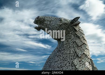 Falkirk, Regno Unito - 20 Giugno, 2022: Una delle sculture a testa di cavallo Kelpies con un cielo espressivo a lunga esposizione alle spalle Foto Stock