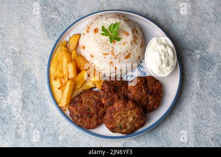 Cibo tradizionale turco; polpette secche o Inegöl con patate e riso pilav (nome turco; kofte Kuru) Foto Stock
