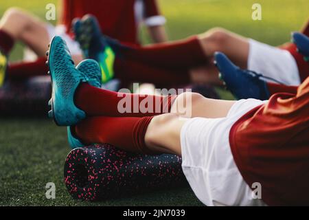 Calcio giocatori di calcio in una squadra su allenamento di idoneità per alleviare la tensione muscolare, il dolore e l'infiammazione. Gruppo di giovani atleti su stretching OU Foto Stock