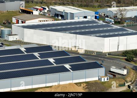 Vista aerea dei pannelli solari fotovoltaici blu montati sul tetto dell'edificio industriale per la produzione di elettricità ecologica verde. Produzione di Foto Stock