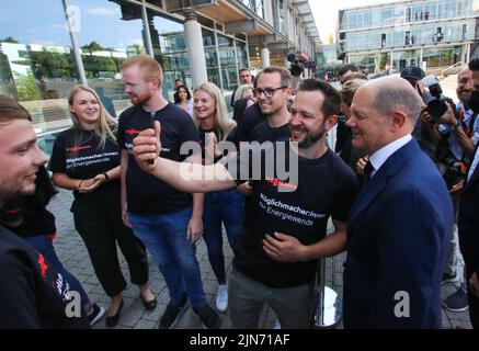 23 maggio 2022, Hessen, Allendorf (Eder): I dipendenti di Viessmann danno il benvenuto al cancelliere tedesco OLAF Scholz (SPD - l) nella sede della società a conduzione familiare Hessian. Scholz ha appreso informazioni sulle pompe di calore e sulle soluzioni per il clima verde presso l'azienda Viessmann. Foto: Nadine Weigel/dpa Foto Stock