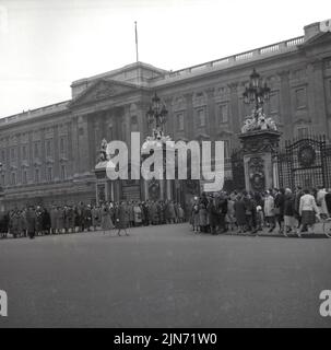 1950s, storico, un gran numero di persone radunate all'esterno alle porte di Buckingham Palace, la residenza londinese della famiglia reale britannica, Londra, Inghilterra, Regno Unito. Foto Stock