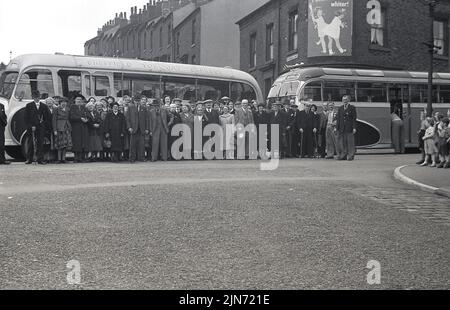 1950s, storico, viaggio in pullman, via Sheffield-Torquay Express, linea di passeggeri maschili e femminili nella strada di Grimesthorpe Rd, Sheffield, South Yorkshire, Inghilterra, Regno Unito, Per una foto prima del viaggio verso sud fino alla località balneare Devon di Torquay, è stato un viaggio di una notte, con partenza il venerdì, arrivo a Torquay sabato mattina, ritorno a Sheffield, domenica. Un'avventura per la fascia d'età. Giovane chidren eccitato in piedi all'angolo della strada. Foto Stock