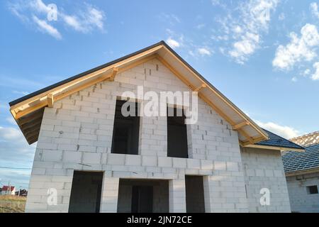 Vista aerea di casa incompiuta con pareti in calcestruzzo leggero aerato e telaio del tetto in legno rivestito con piastrelle metalliche in costruzione Foto Stock