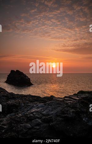 Il sole l'impostazione off le falesie sopra Boscastle Harbour in Cornovaglia, England, Regno Unito Foto Stock