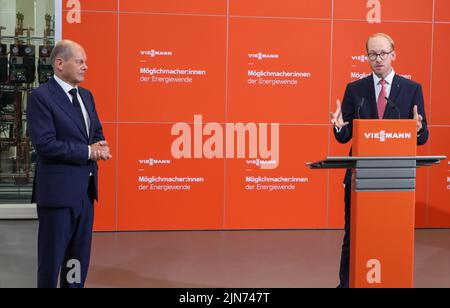 09 agosto 2022, Hessen, Allendorf (Eder): L'Amministratore Delegato Max Viessmann (r) dà il benvenuto al Cancelliere tedesco OLAF Scholz (SPD) durante la sua visita alla società di tecnologia del riscaldamento. Scholz ha imparato a conoscere le pompe di calore e le soluzioni per il clima verde dell'azienda a conduzione familiare. Foto: Nadine Weigel/dpa Foto Stock