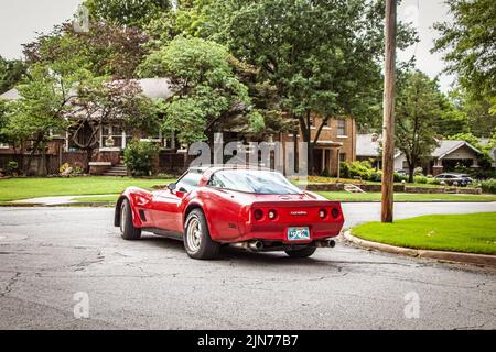 6-9-2022 Tulsa USA - Red Corvette si prepara a svoltare all'incrocio in quartiere residenziale in estate Foto Stock