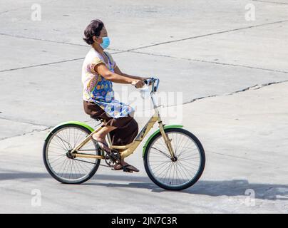 SAMUT PRAKAN, THAILANDIA, 09 2022 GIUGNO, Una donna di giro in bicicletta in strada città. Foto Stock