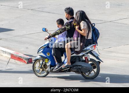 SAMUT PRAKAN, THAILANDIA, 09 2022 GIUGNO, Un uomo guida una moto con una donna e un ragazzo in una divisa scuola Foto Stock