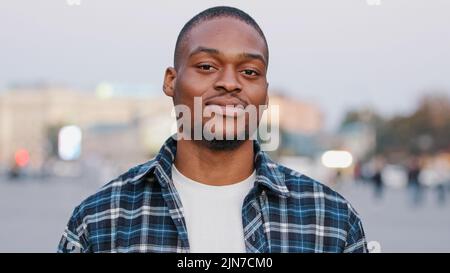 Chiamami segno. Simbolo di chiamata. Uomo afro-americano positivo guardando la macchina fotografica giocoso flirting ragazzo in città tenendo il telefono mano gesto vicino orecchio Foto Stock