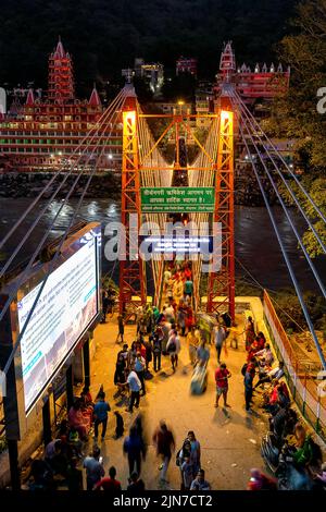 Uno scatto verticale del ponte illuminato Rishikesh e del fiume Ganges a Uttarakhand, India Foto Stock